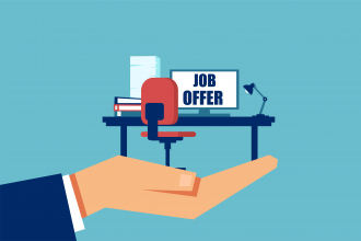 Hand hält einen Bürostuhl und Schreibtisch in der Hand, darauf die Aufschrift "Job Offer"